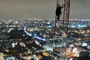 man_standing_on_city_crane_at_nigh_450